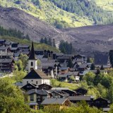 Une vue prise un jour après l'effondrement du glacier du Brich avec le village de Kippel. On devine à l'arrière-plan le village de Blatten englouti par l'écroulement. KEYSTONE/JEAN-CHRISTOPHE BOTT